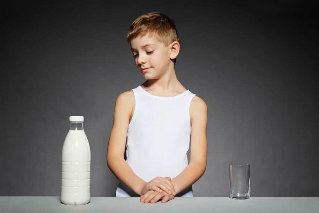 Boy standing and looking at milk