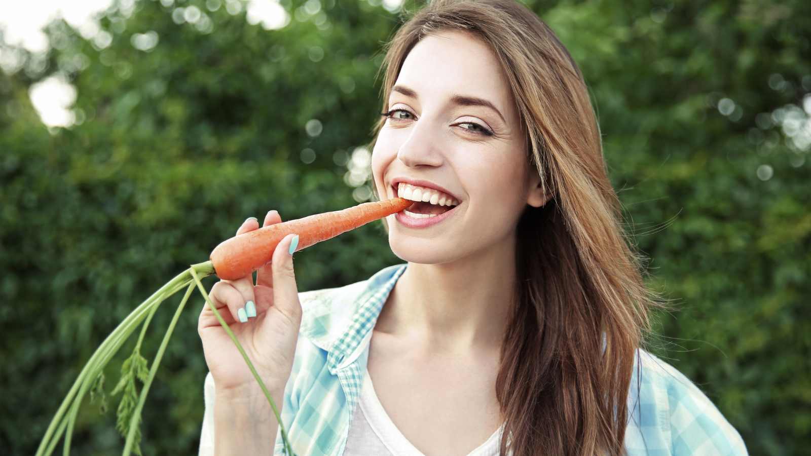 woman eating carrot outdoor