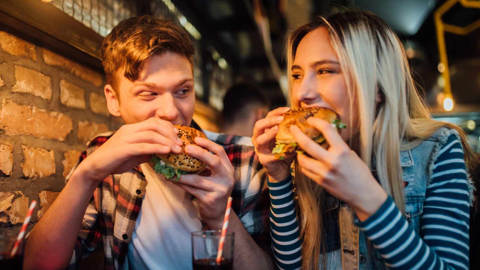 lady and man eating cheeseburger