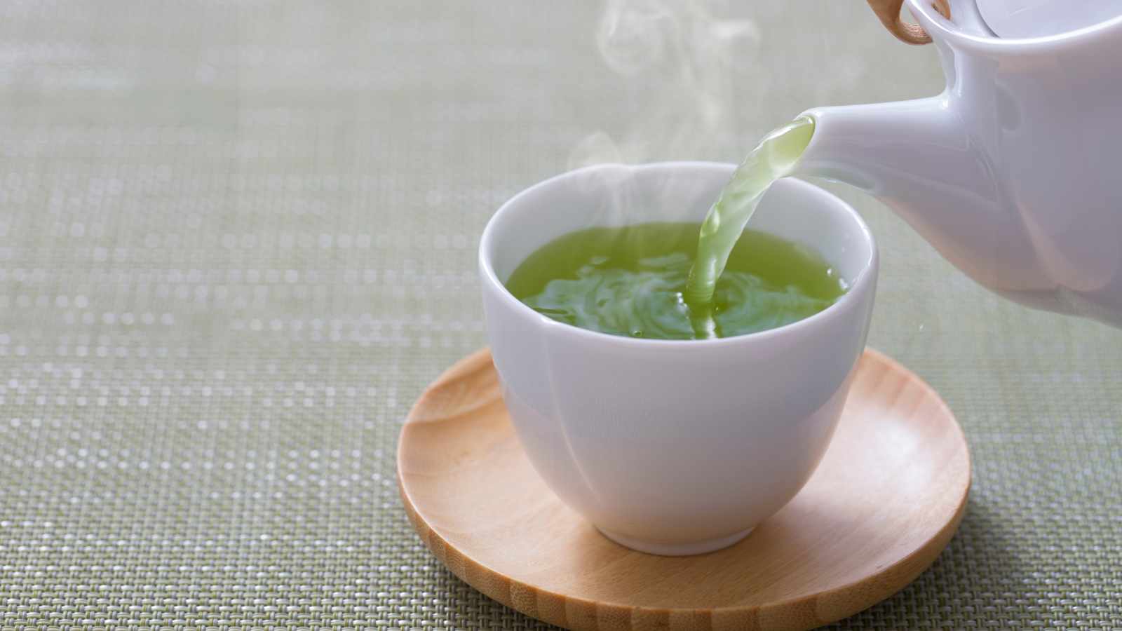 Green tea pouring from a kettle