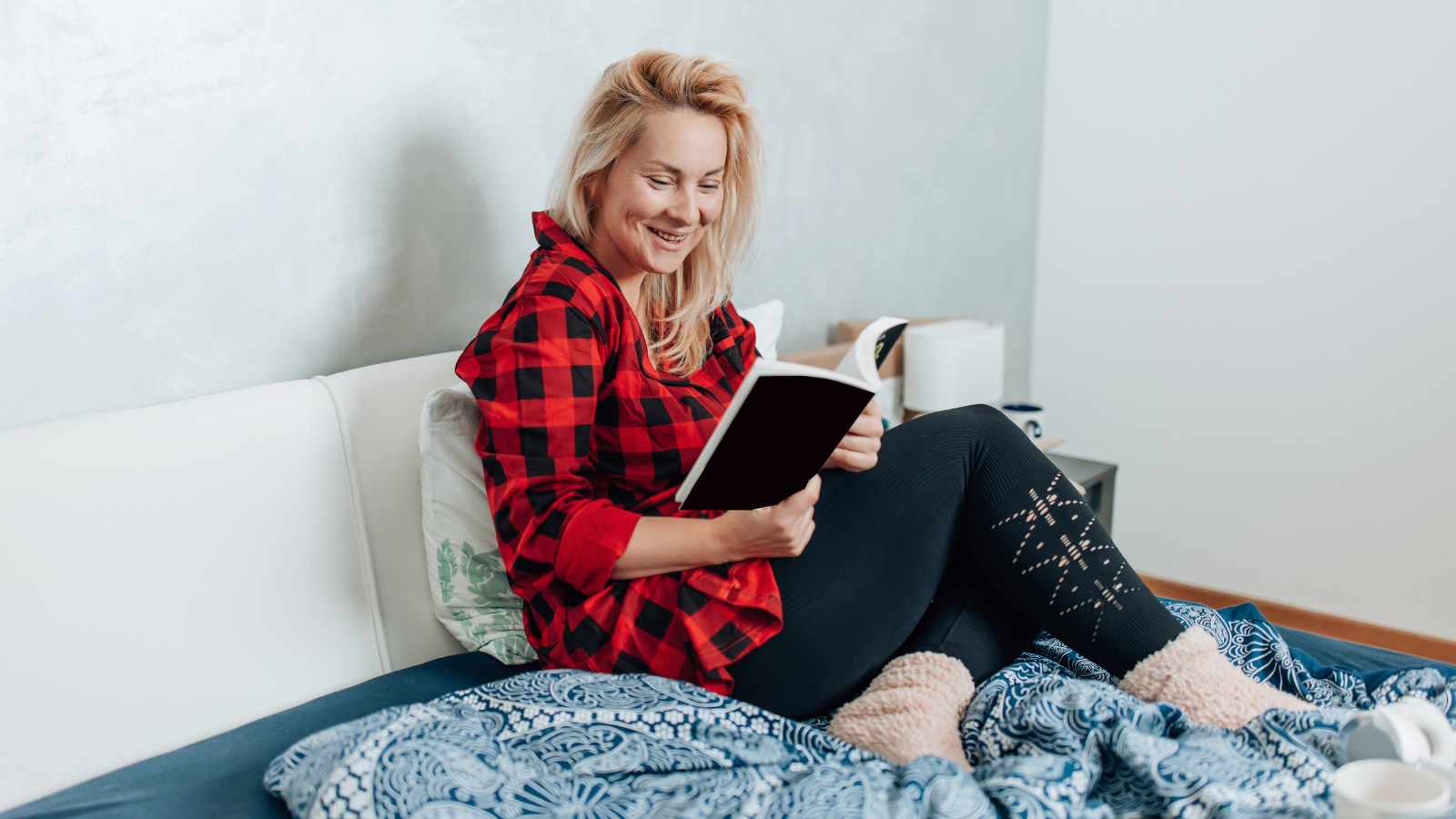 Lady reading a book in bed