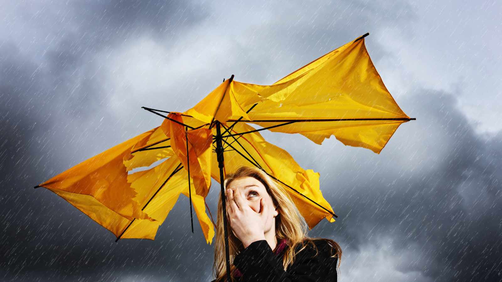 Lady with torn umbrella under a storm