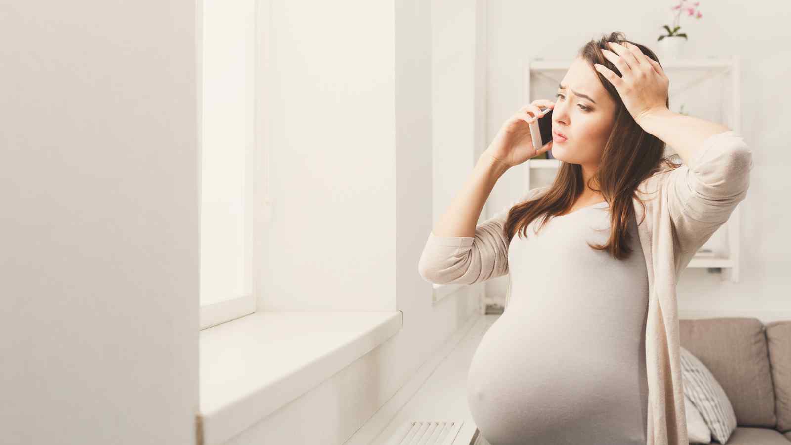 worried pregnant woman on phone