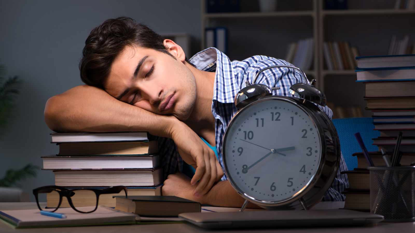 man sleeping on a pile of books