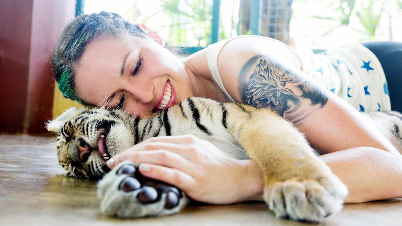 Lady petting a baby tiger