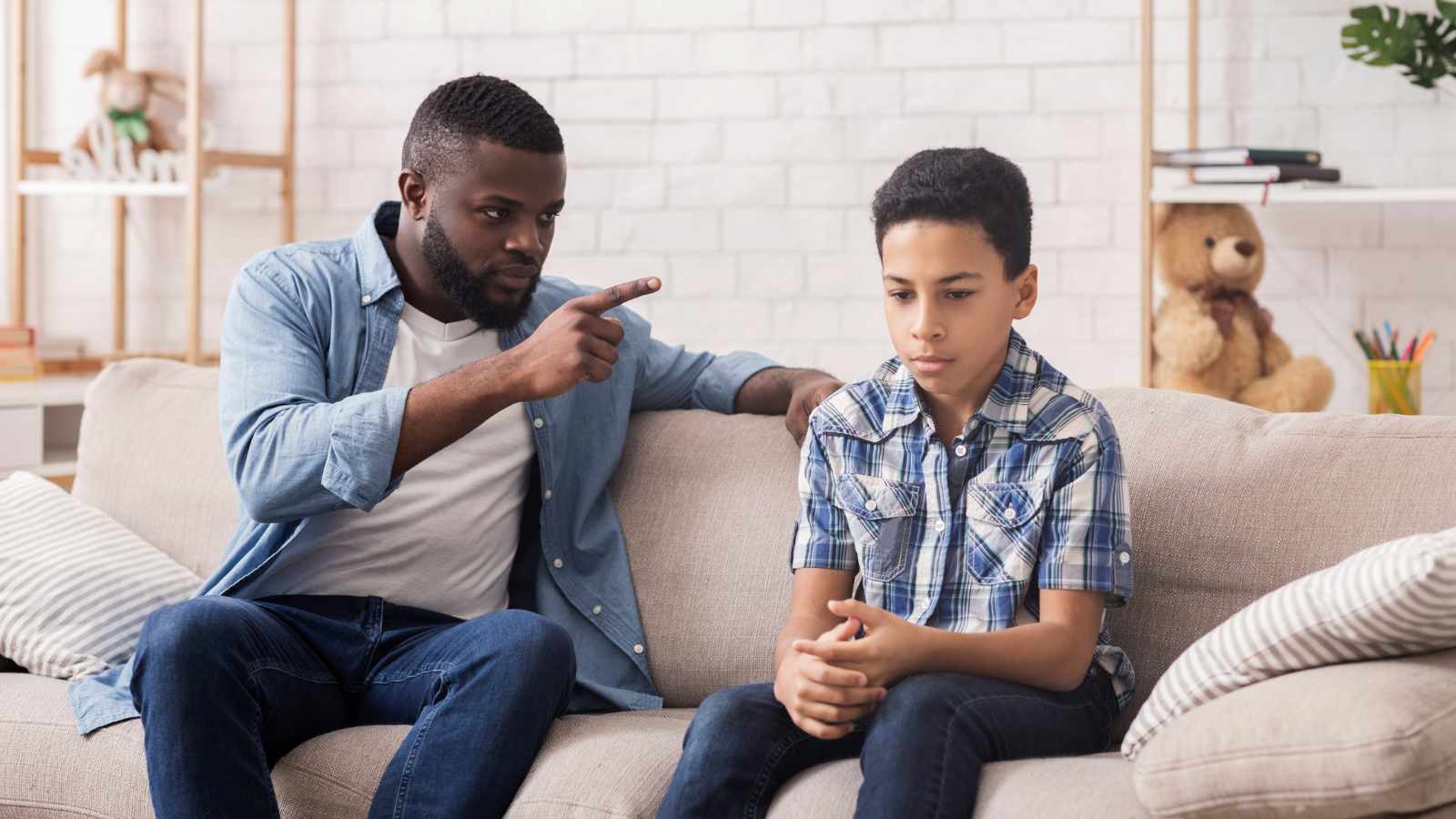 Man scolding upset son