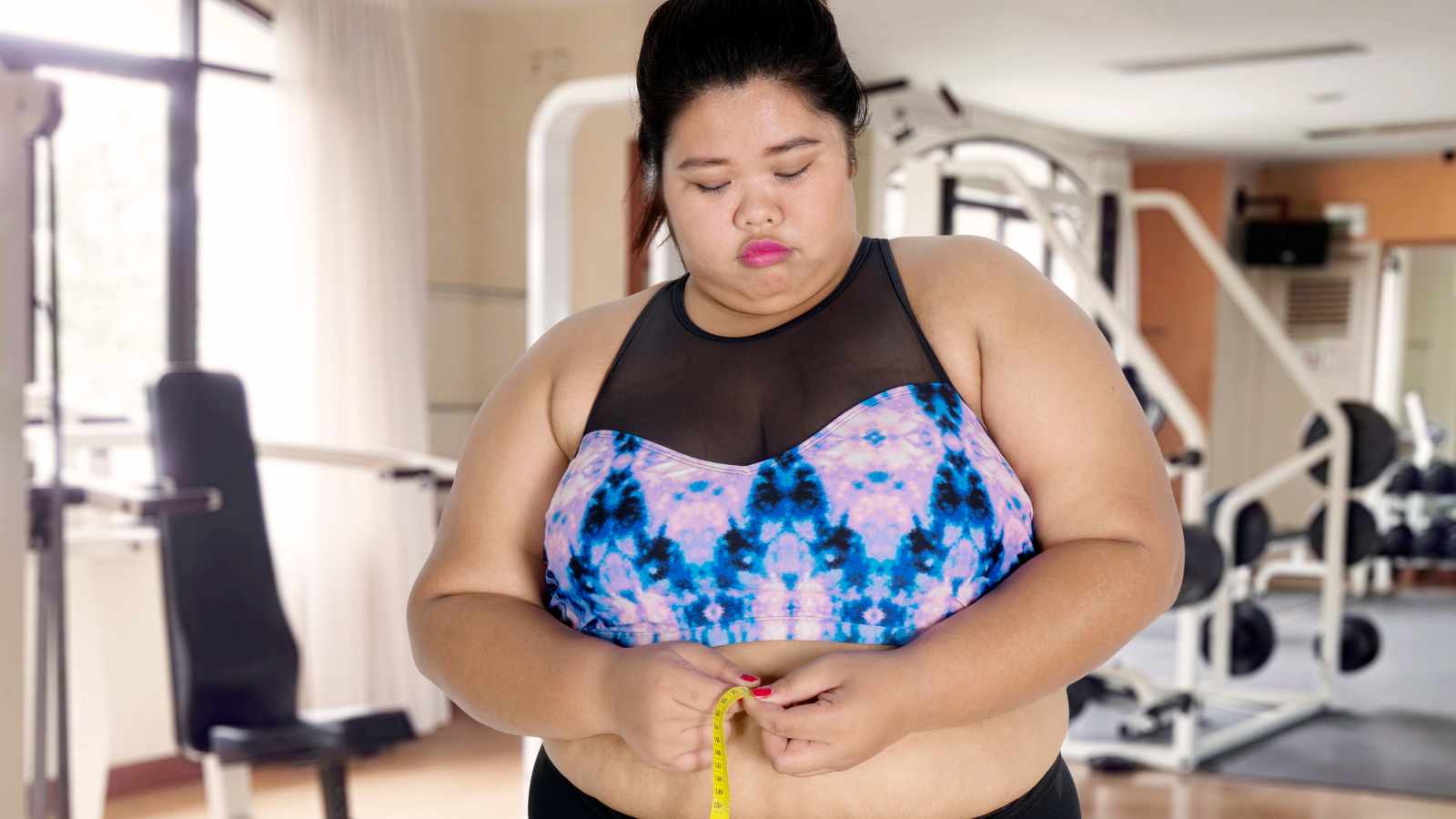 Obese lady measuring her waist